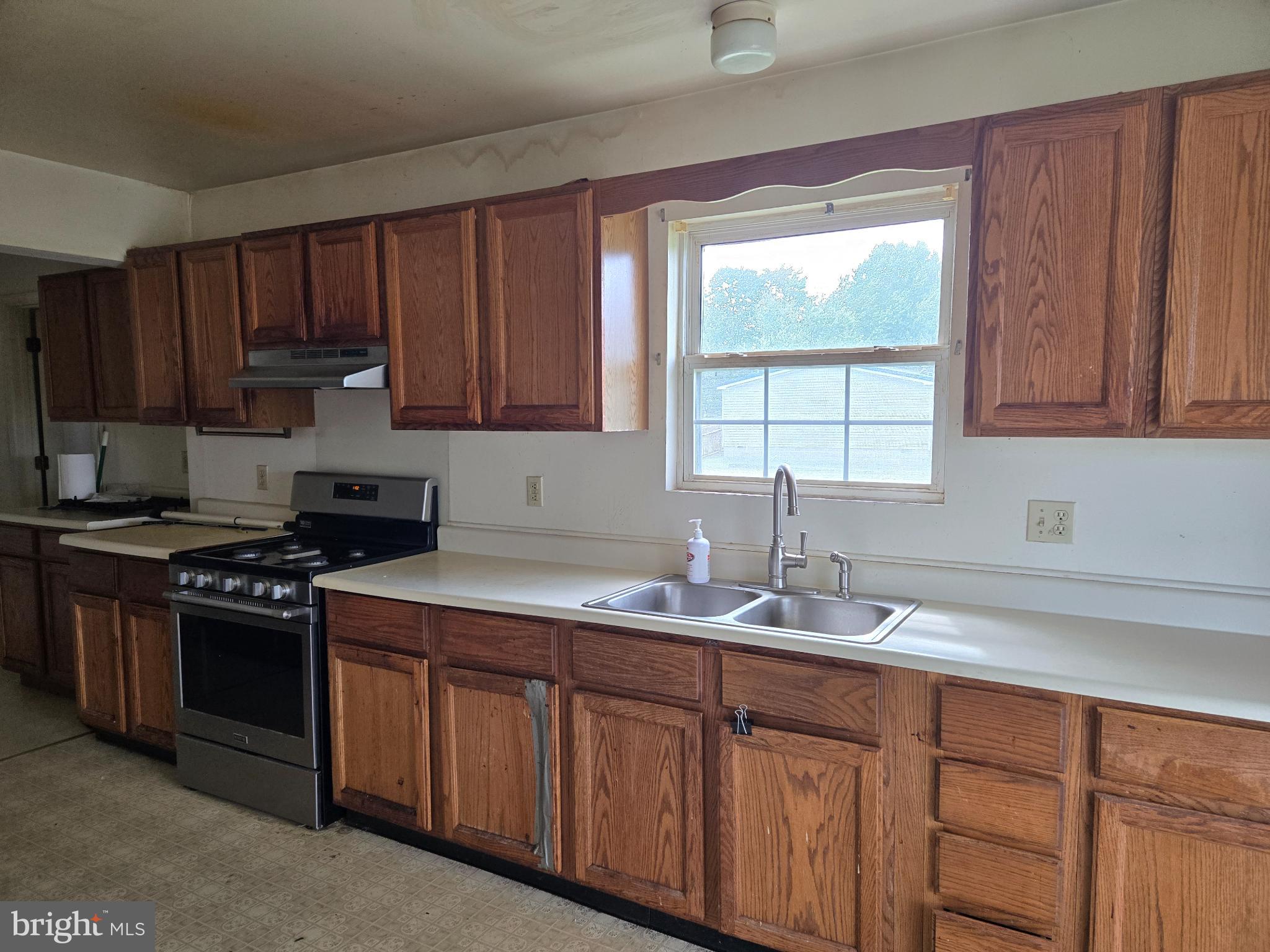 8806 Greentop Road Lincoln, DE 19960 - Photo 12 of 35 a kitchen with granite countertop wooden cabinets a sink and a stove