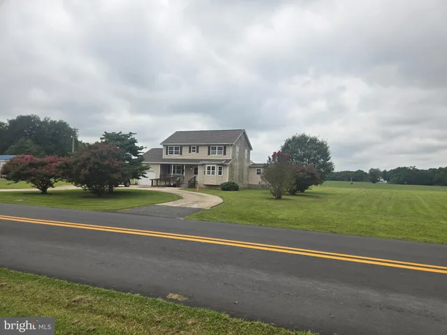 a view of a big house with a big yard and large trees