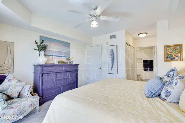 a bedroom with a bed couch and a potted plant