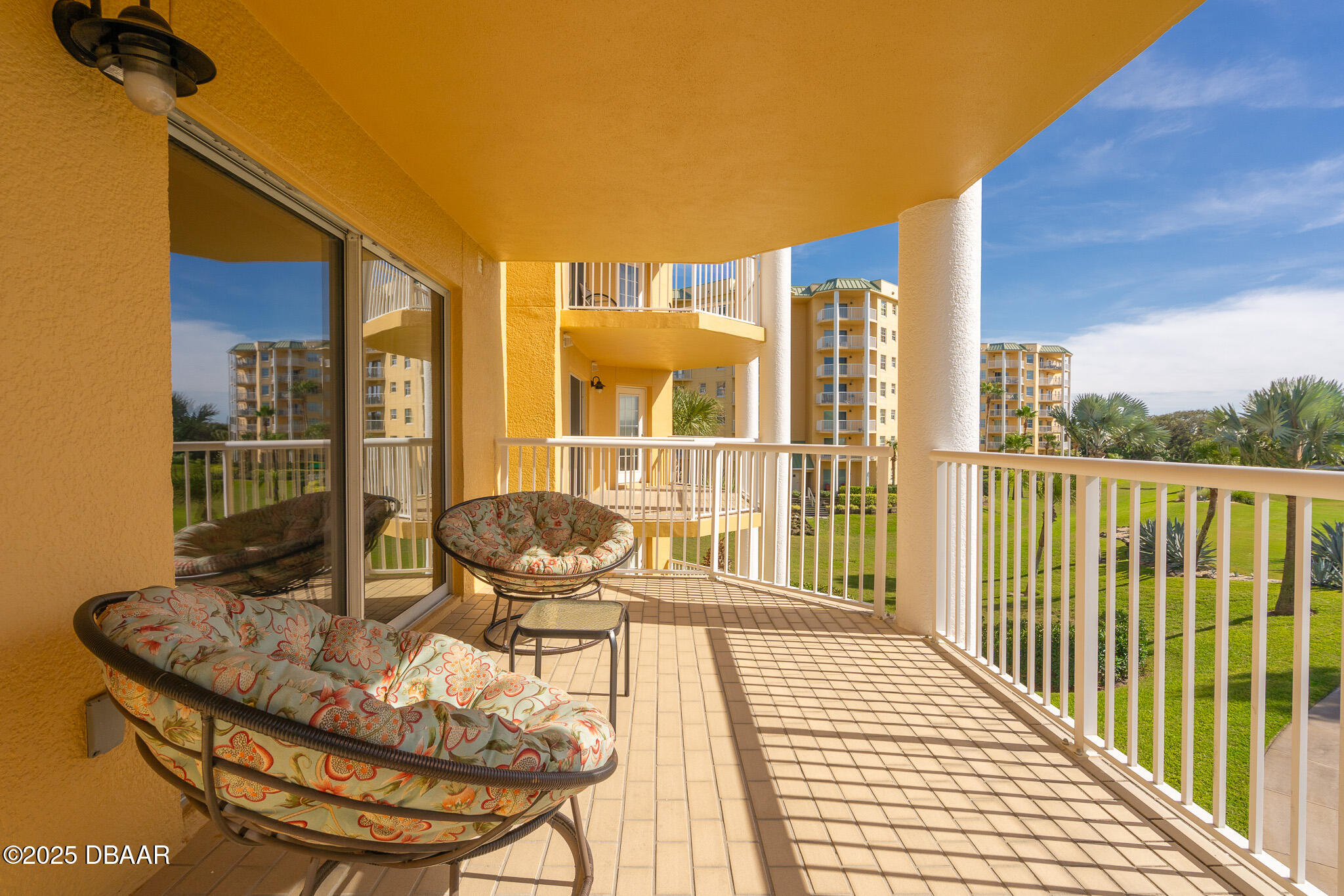 4650 Links Village Drive, Unit C303 Ponce Inlet, FL 32127 - Photo 32 of 67 a view of a balcony with chair and wooden floor