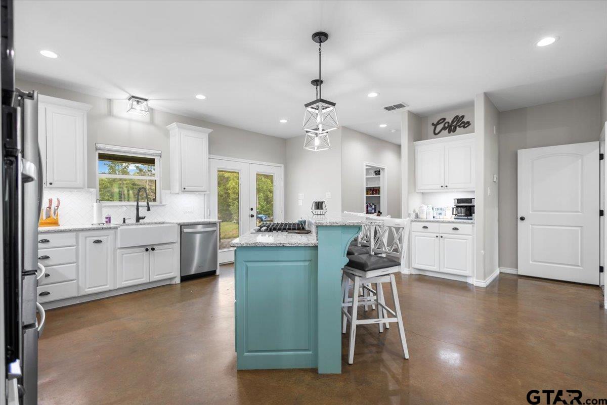 9235 Farm To Market Road 851 Rusk, TX 75785 - Photo 11 of 47 a kitchen with stainless steel appliances kitchen island granite countertop a stove a sink a oven a dining table and chairs