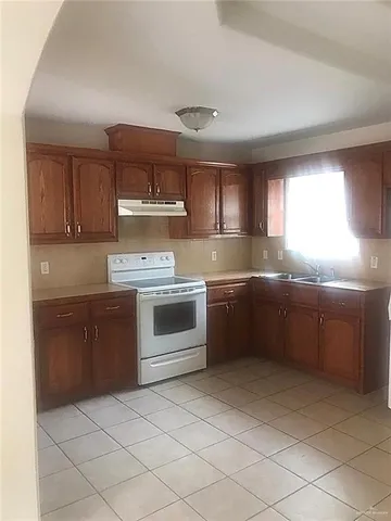 a kitchen with a stove sink and cabinets