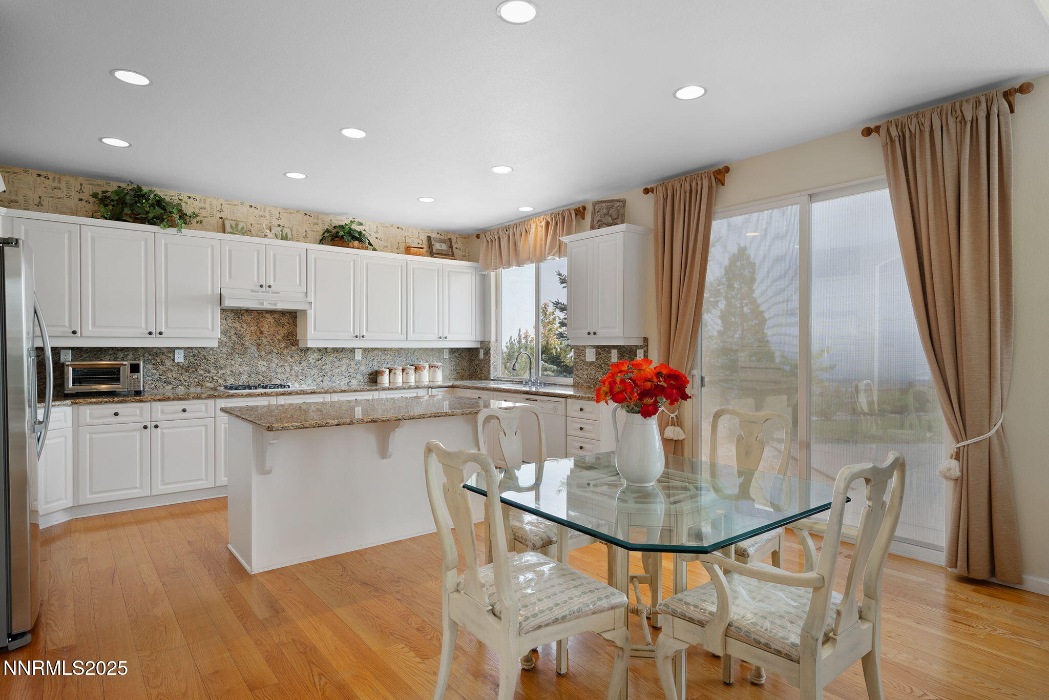 3206 Old Coach Court Reno, NV 89511 - Photo 15 of 40 a kitchen with stainless steel appliances granite countertop a stove a sink a dining table and chairs