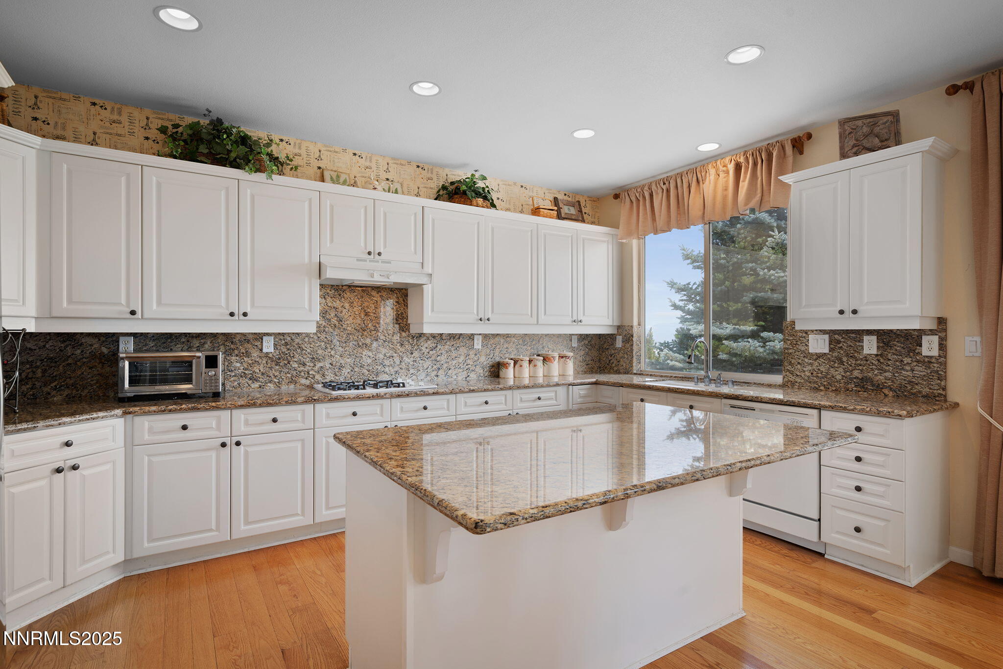 3206 Old Coach Court Reno, NV 89511 - Photo 17 of 40 a kitchen with granite countertop white cabinets and white appliances