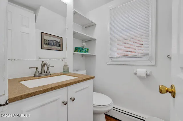 a bathroom with a sink mirror vanity and toilet