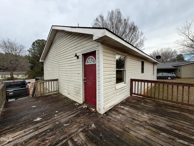a view of a house with wooden deck front of house