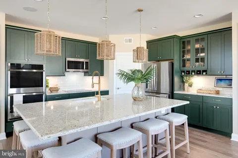 a large kitchen with granite countertop a counter space a sink stainless steel appliances and cabinets