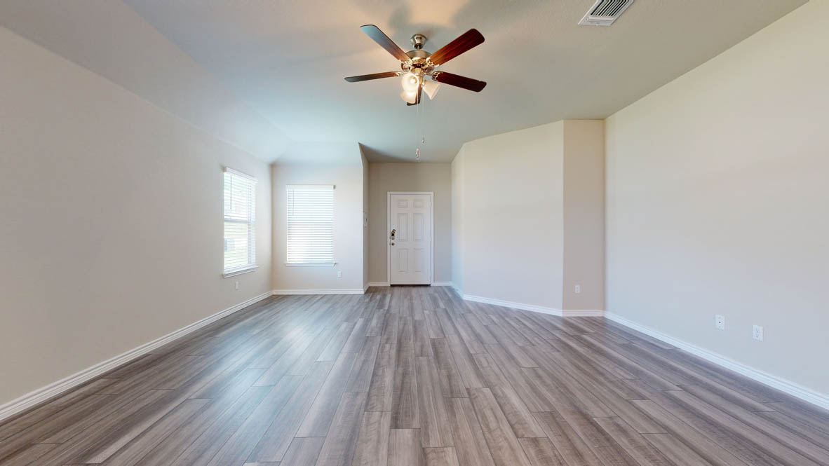 104 Kenzie Street Thorndale, TX 76577 - Photo 2 of 28 wooden floor in an empty room with a window