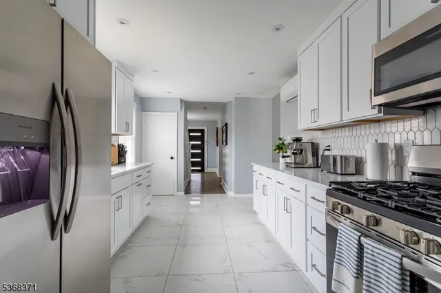 a kitchen with stainless steel appliances granite countertop a refrigerator and a stove top oven