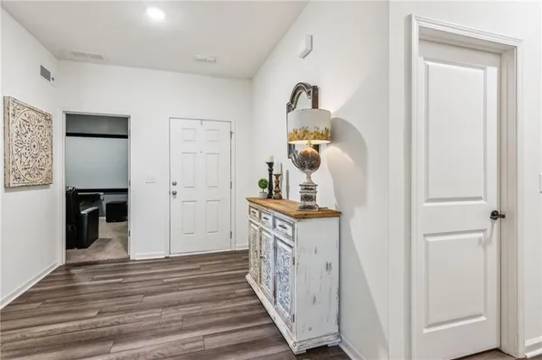 a view of a hallway with wooden floor and closet