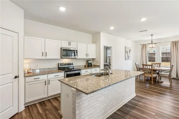 a kitchen with stainless steel appliances granite countertop a refrigerator stove microwave and sink