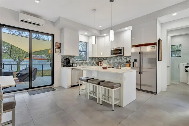 a kitchen with white cabinets and refrigerator