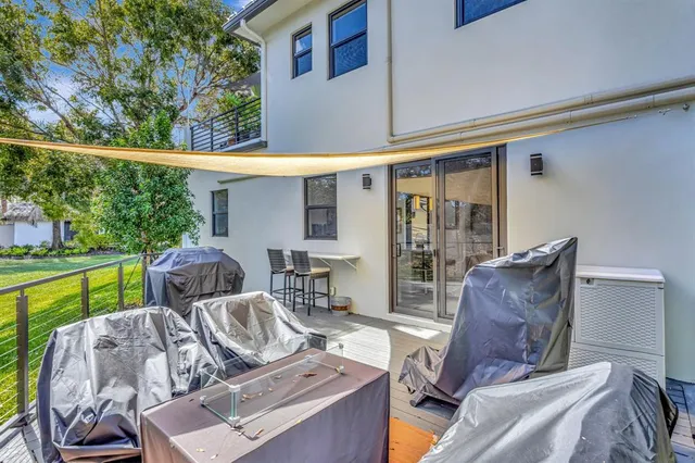 a view of a patio with table and chairs potted plants with wooden floor and fence
