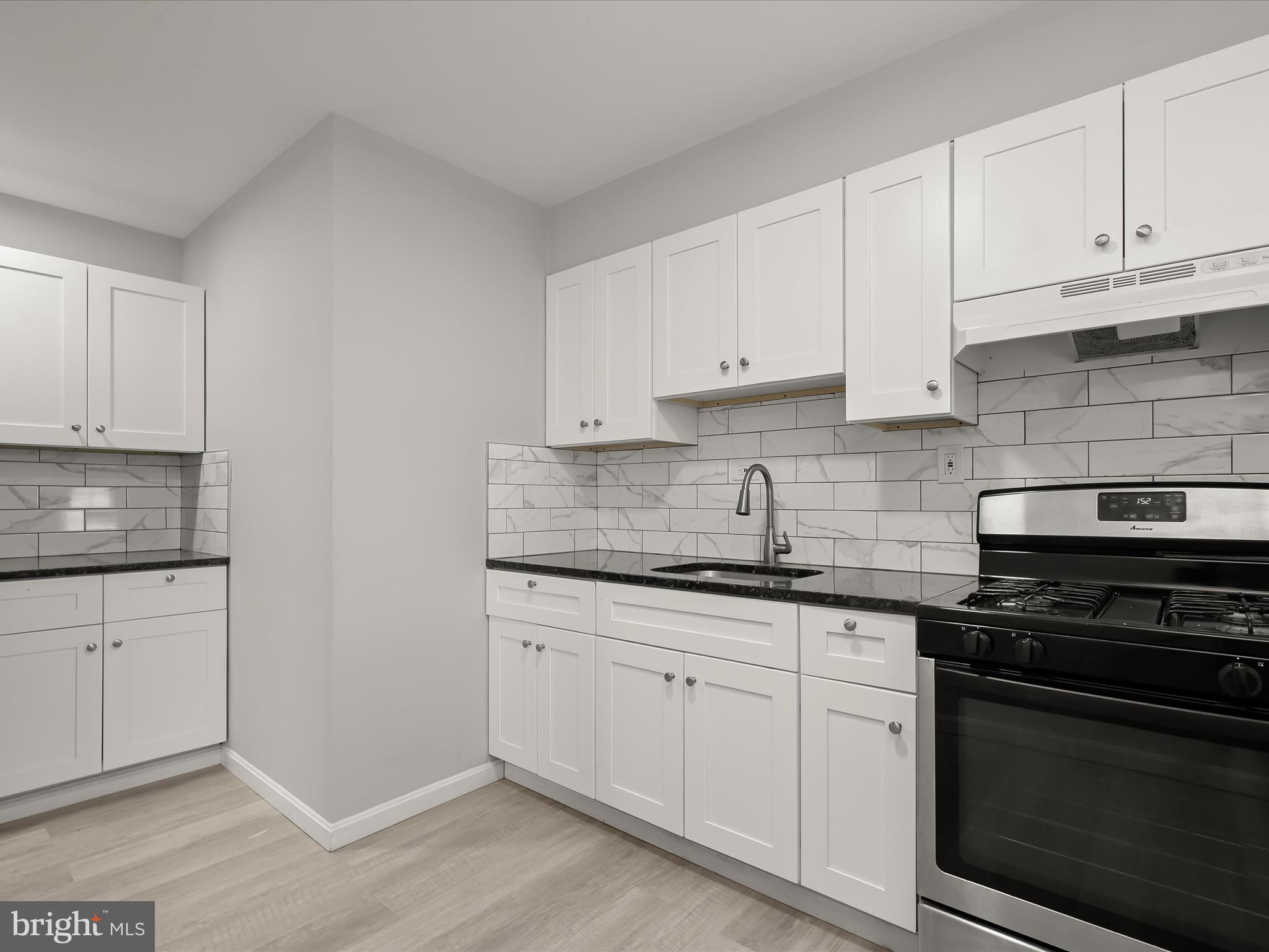 714 Stamford Road Baltimore, MD 21229 - Photo 11 of 31 a kitchen with granite countertop white cabinets and stainless steel appliances