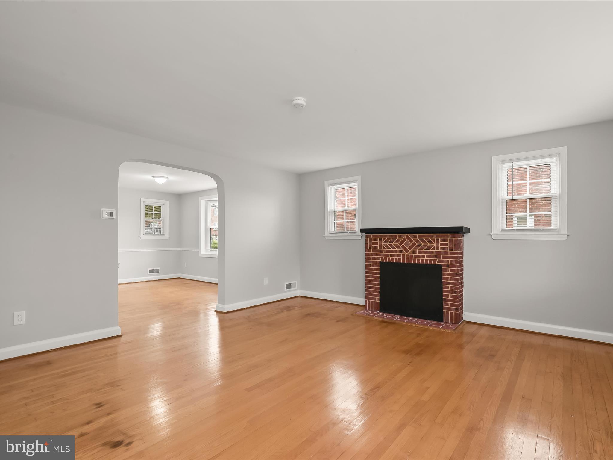 714 Stamford Road Baltimore, MD 21229 - Photo 6 of 31 a view of an empty room with a fireplace and a window