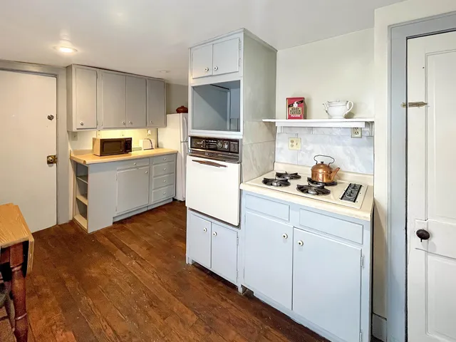 a kitchen with cabinets and wooden floor