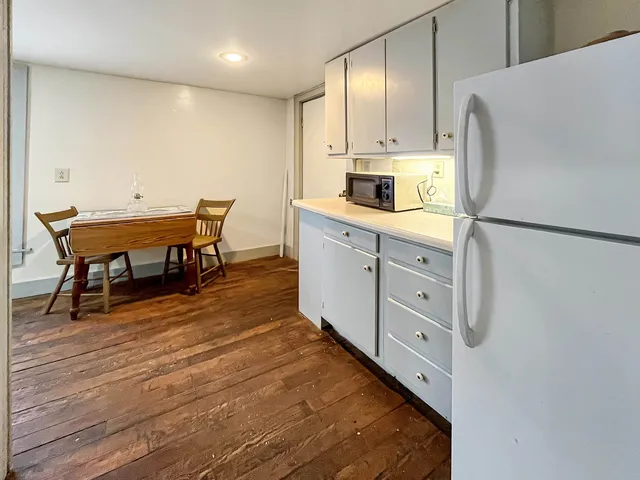 a kitchen with stainless steel appliances white cabinets and wooden floor