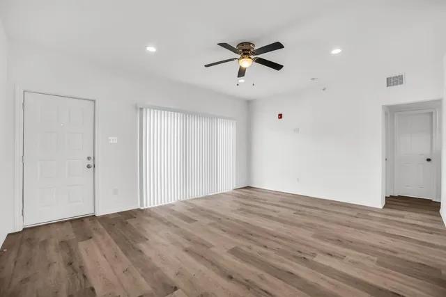 a view of an empty room with wooden floor