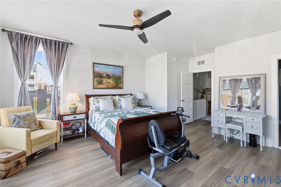 585 Hazel Place, Unit A Henrico, VA 23233 - Photo 14 of 26 a bedroom with a bed a couch and a chandelier