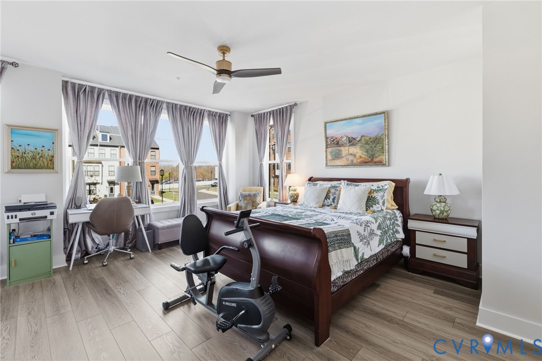 585 Hazel Place, Unit A Henrico, VA 23233 - Photo 16 of 26 a spacious bedroom with a bed a desk and chair with wooden floor