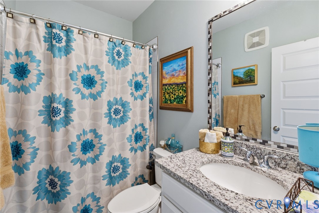 585 Hazel Place, Unit A Henrico, VA 23233 - Photo 21 of 26 a bathroom with a granite countertop toilet sink and mirror