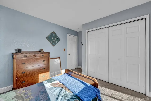 a room with a bed and a lamp on a dresser