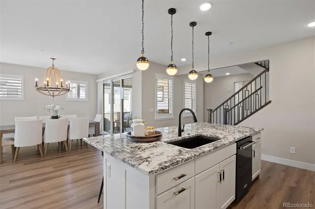 a kitchen with granite countertop a sink cabinets and wooden floor