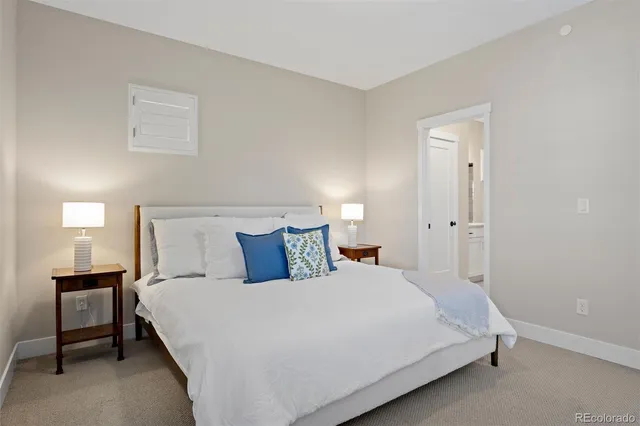 a large bed sitting in a bedroom next to a lamp