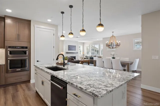 a kitchen with granite countertop a sink cabinets and stainless steel appliances