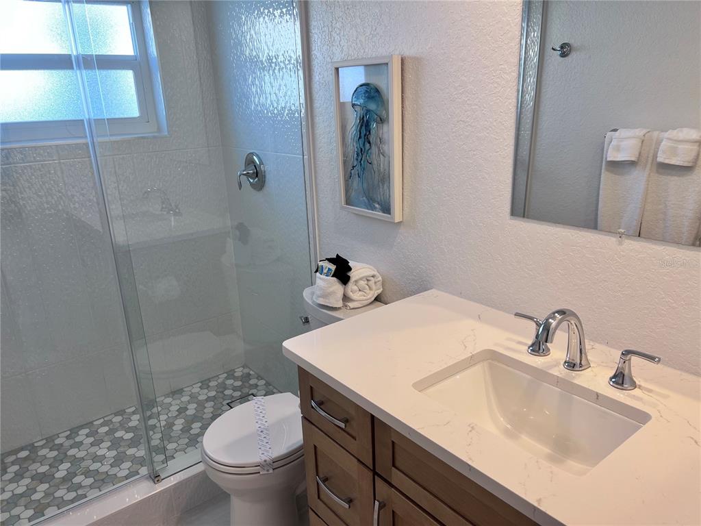 6154 Midnight Pass Road, Unit B06 Sarasota, FL 34242 - Photo 12 of 18 a bathroom with a sink toilet and shower