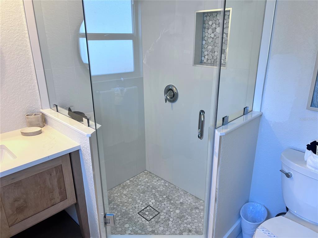 6154 Midnight Pass Road, Unit B06 Sarasota, FL 34242 - Photo 17 of 18 a bathroom with a sink a toilet a shower and mirror