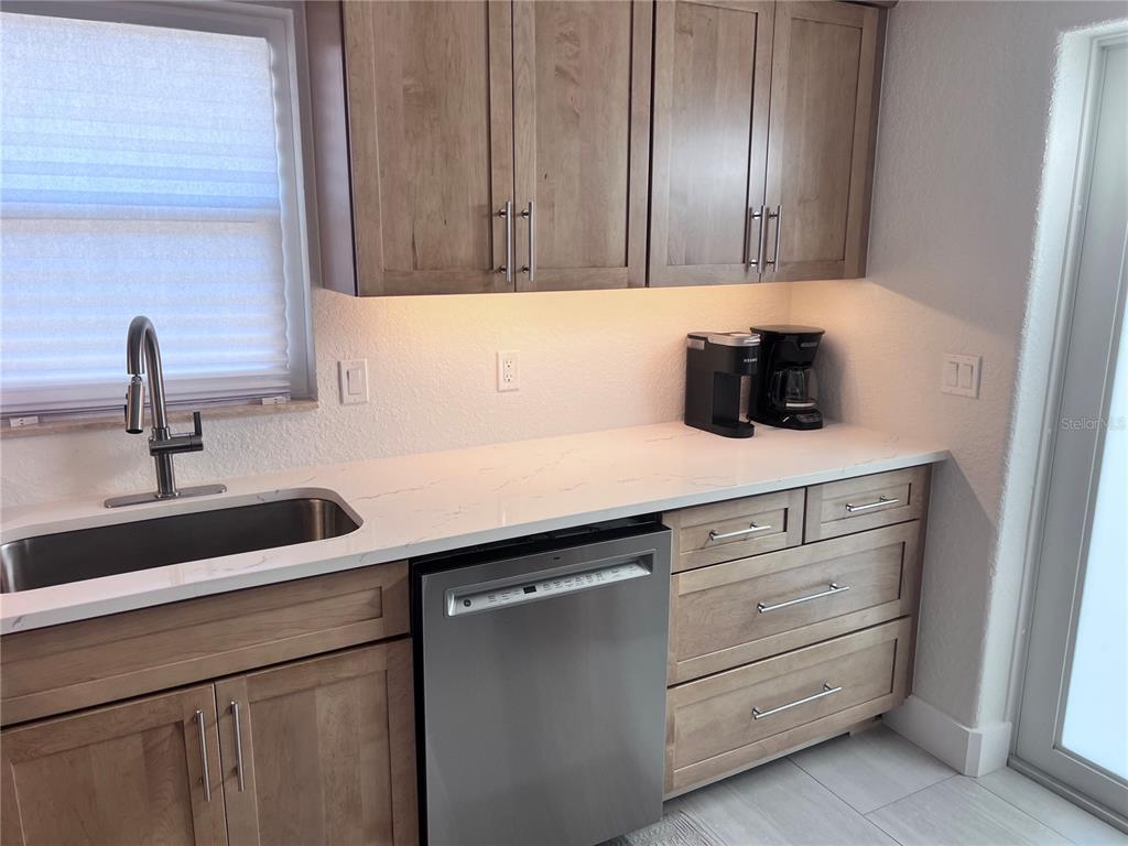 6154 Midnight Pass Road, Unit B06 Sarasota, FL 34242 - Photo 5 of 18 a view of a sink and dishwasher in a kitchen