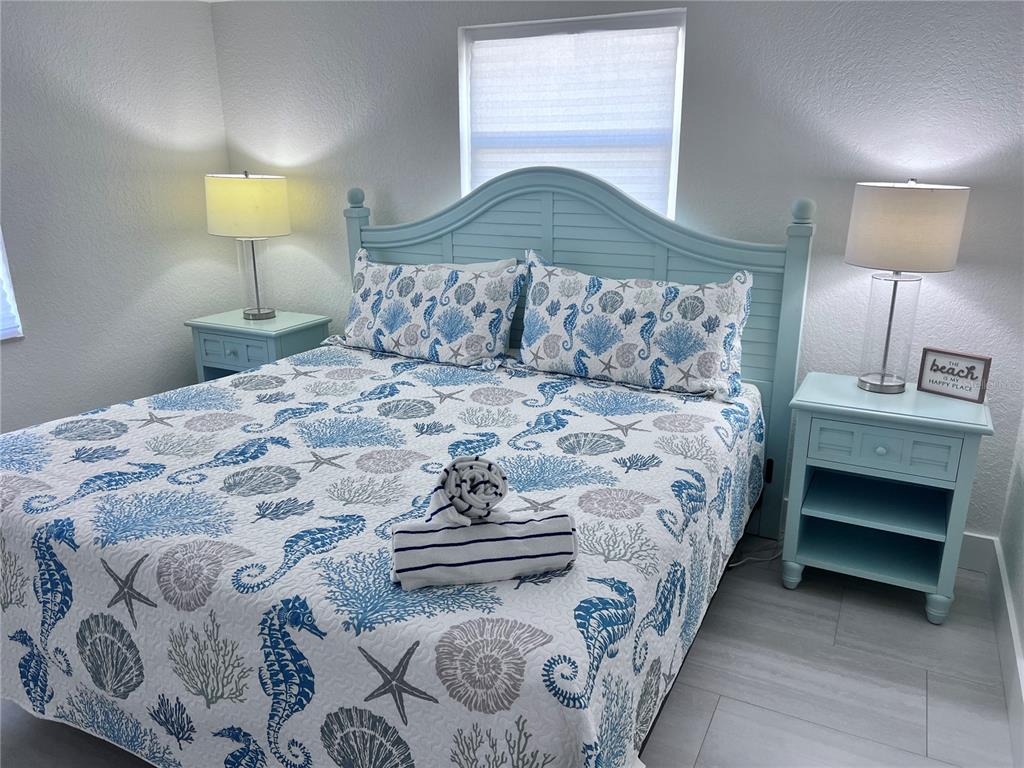 6154 Midnight Pass Road, Unit B06 Sarasota, FL 34242 - Photo 10 of 18 a bedroom with a bed and a lamp