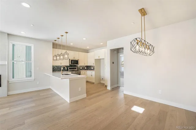 a kitchen with kitchen island white cabinets and wooden floor