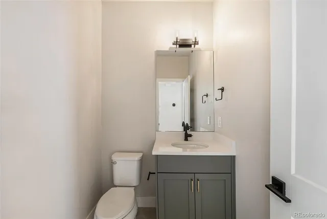 a bathroom with a toilet a sink and mirror