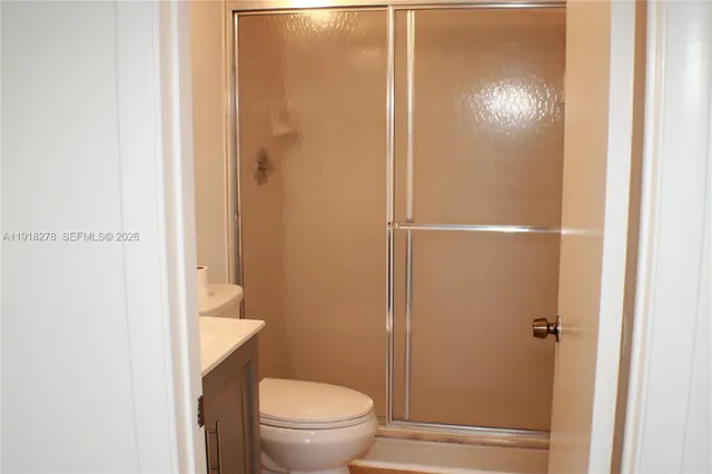 a bathroom with a granite countertop toilet and a shower