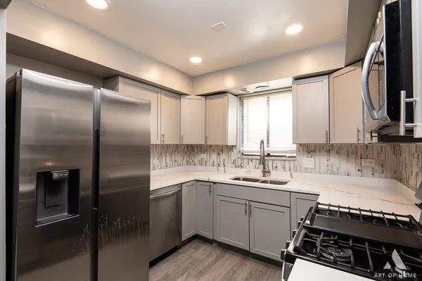 a kitchen with a sink appliances and cabinets