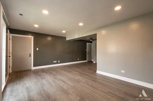 a view of an empty room with wooden floor
