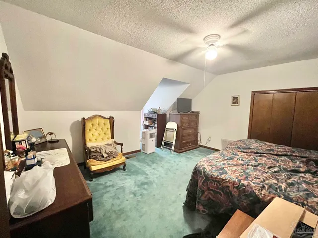 a bedroom with bed and a mirror