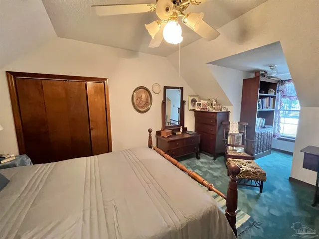 a bedroom with a bed a chandelier and dresser