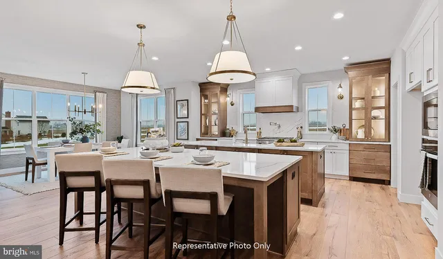 a kitchen with stainless steel appliances a dining table chairs stove and white cabinets