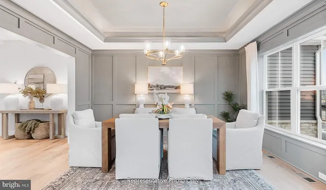 a dining room with furniture a chandelier and window