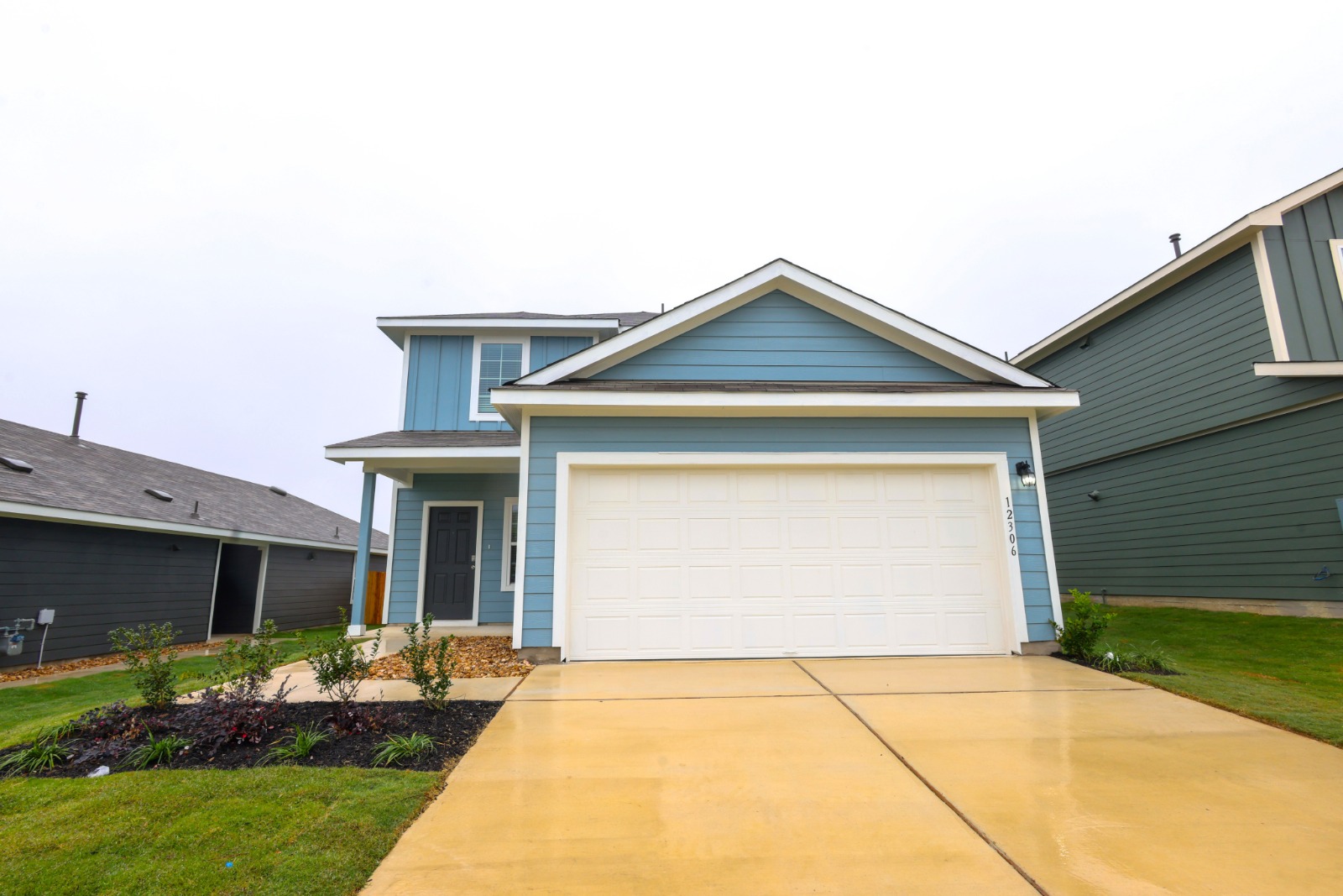 12306 Bulldogger Bend Buda, TX 78610 - Photo 9 of 11 a front view of a house with a garden and plants