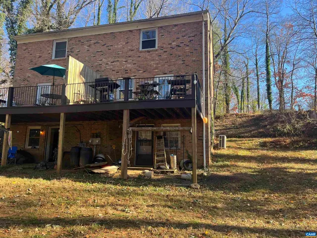 a view of a brick house with large windows and a small yard