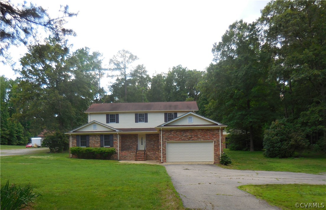 a front view of a house with a yard and trees