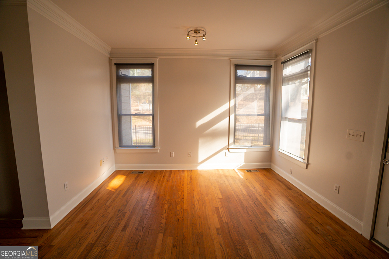 901 Custer Avenue Southeast Atlanta, GA 30315 - Photo 9 of 21 a view of an empty room with wooden floor and a window