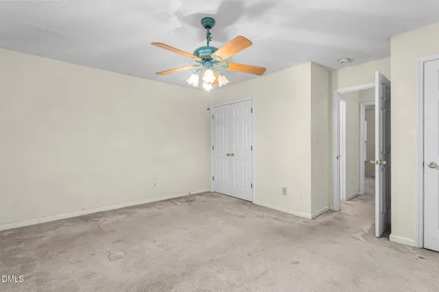 an empty room with a window and a fan