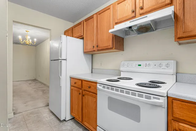 a kitchen with stainless steel appliances granite countertop a refrigerator and a stove