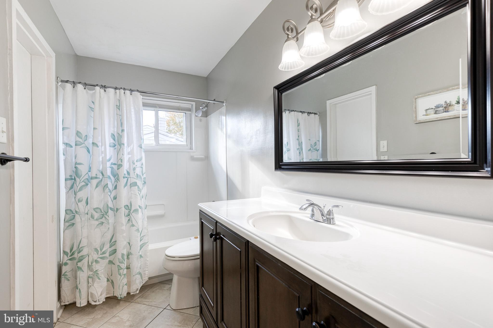 913 Marksworth Road Catonsville, MD 21228 - Photo 25 of 36 a bathroom with a granite countertop sink a toilet and a mirror