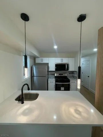 a kitchen with kitchen island a sink stainless steel appliances and cabinets